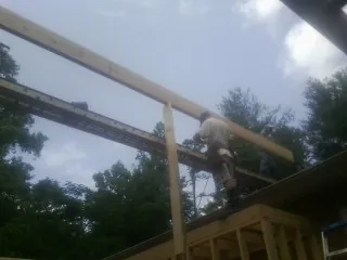 Carpenter setting a ridge beam over a new addition frame — Ice Dam Removal by Roofing Brothers in Marne