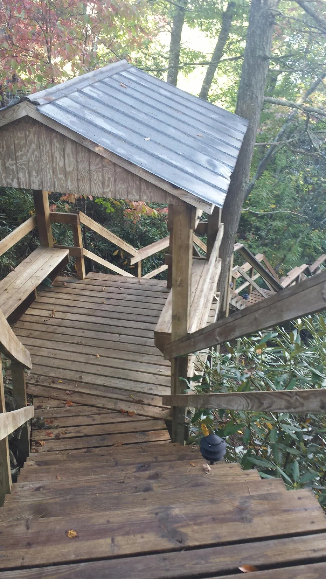 Metal roofed shelter over wooden steps on a wooded walkway — Skylight Repair & Installation work by our crew in Marne
