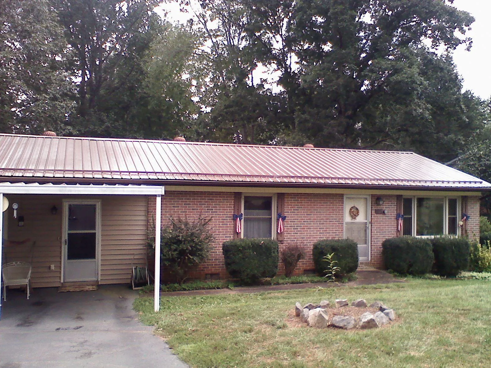 Bronze metal roof and carport on a brick ranch home — Roof Repair work by our crew in Marne